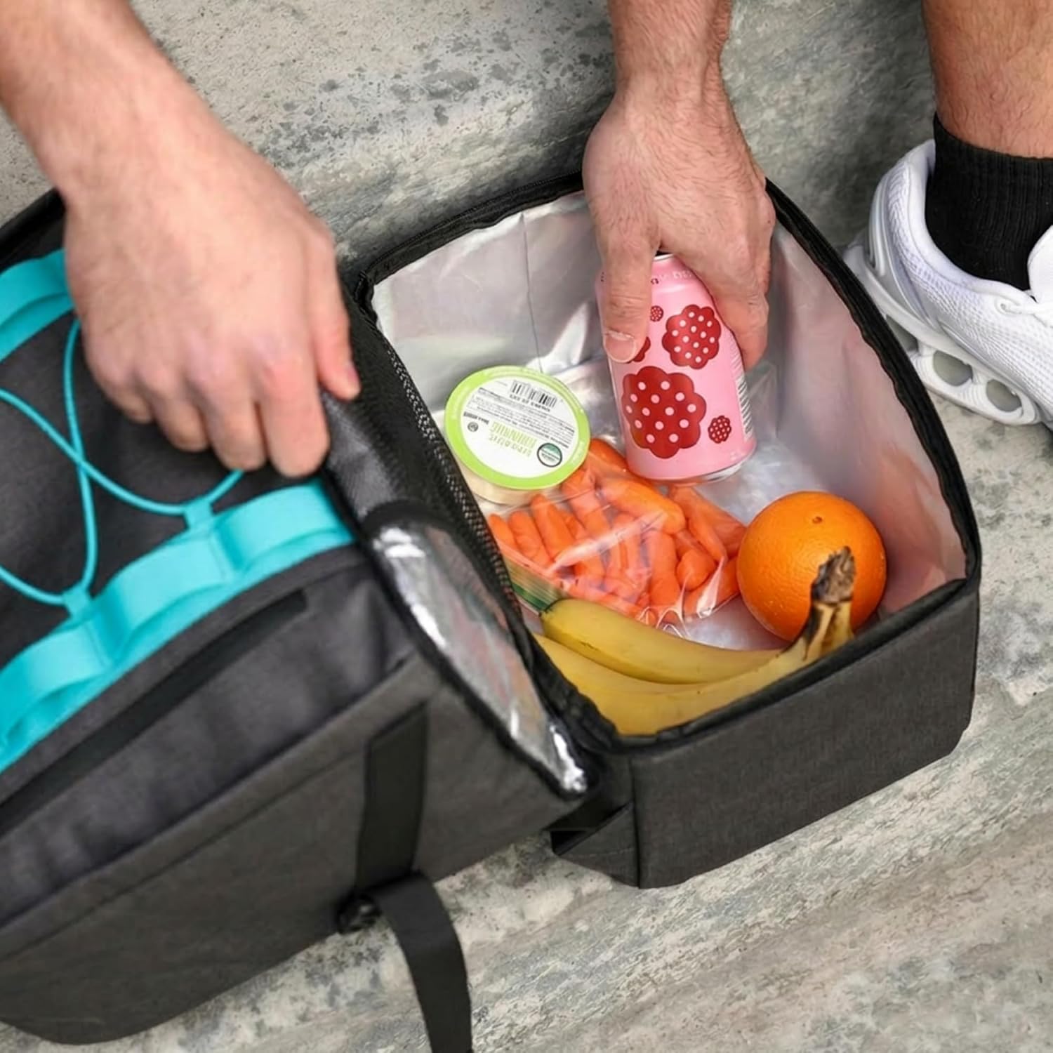 The insulated lower compartment open with fruit and food containers inside